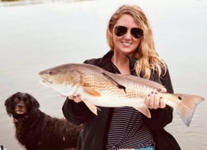 Capt. Jesse with beautiful tagged redfish (pupper photobomb)